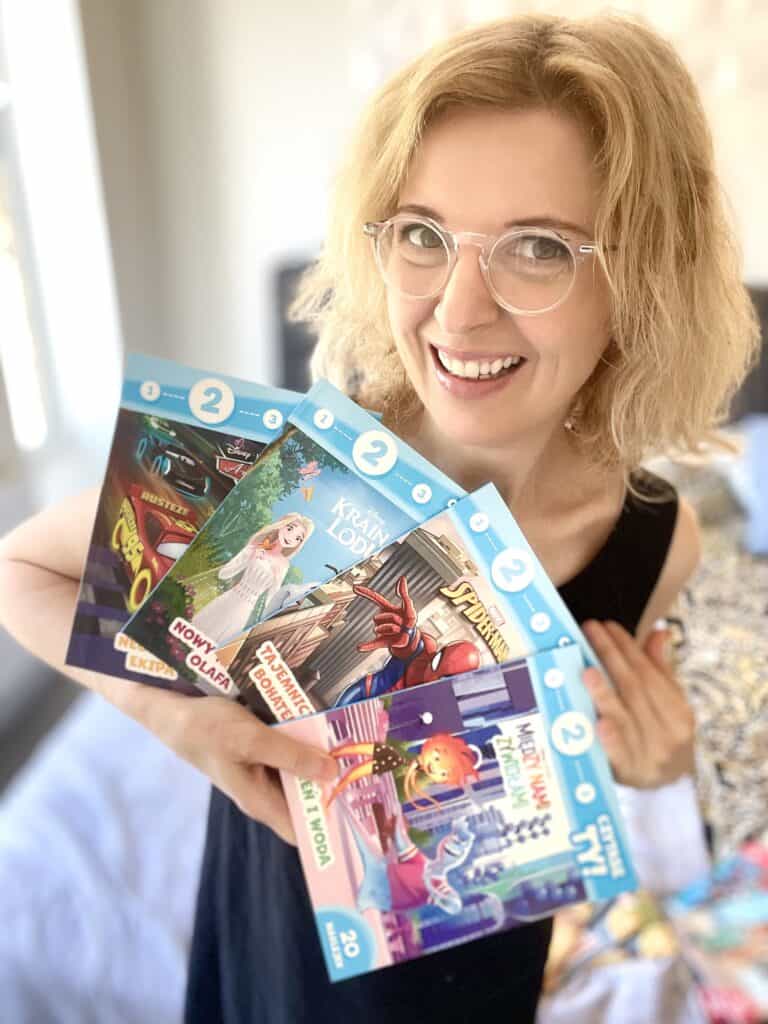 A woman holding up a bunch of books.