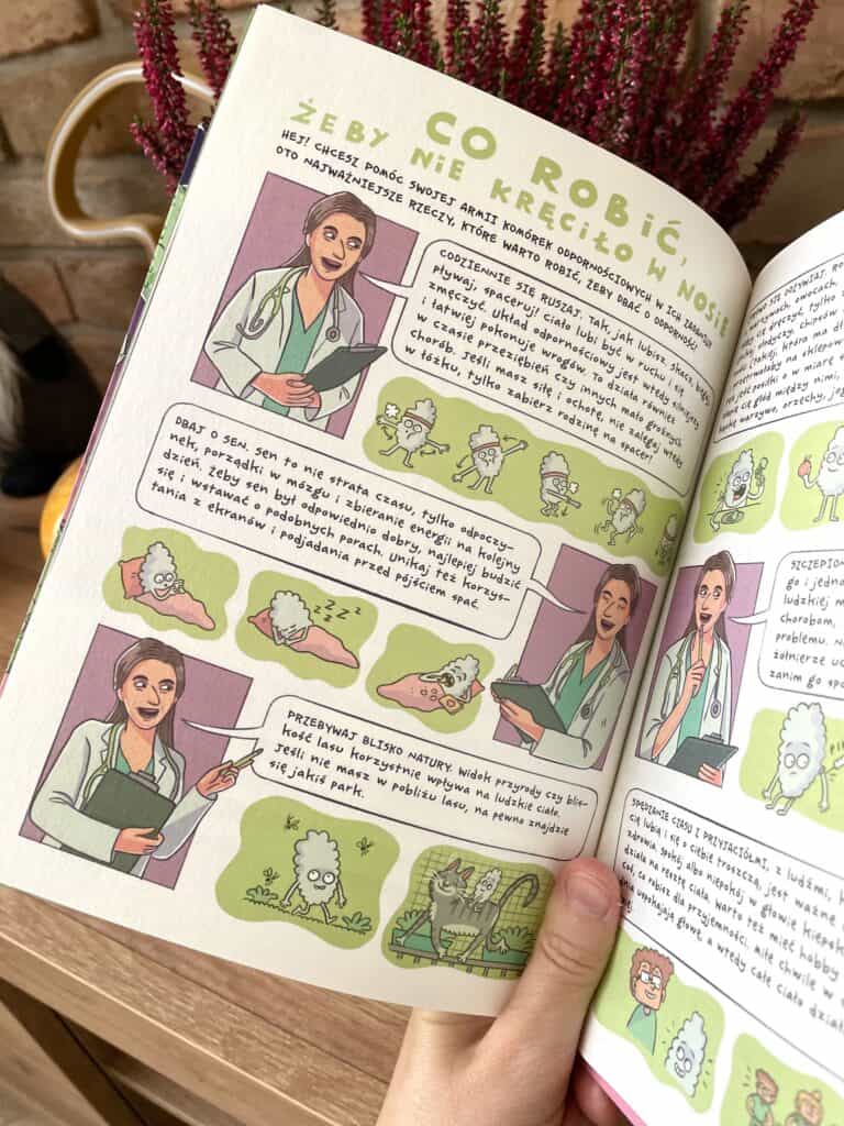 A person is holding a book with illustrations of people.