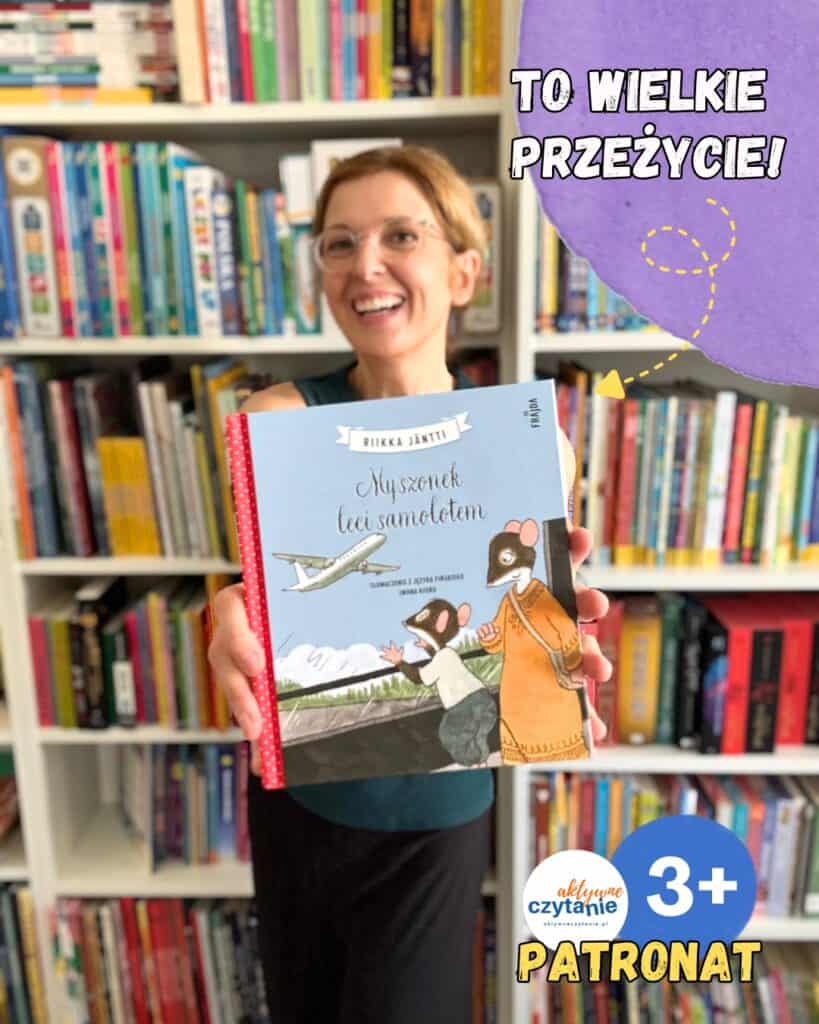 Dziecko trzymające książkę w bibliotece, promujące czytanie dla dzieci.