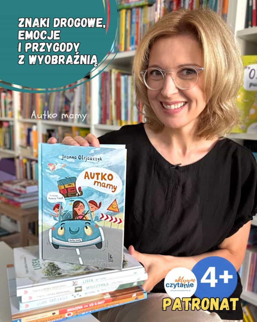 Kobieta trzymająca książkę Autko mamy w bibliotece.