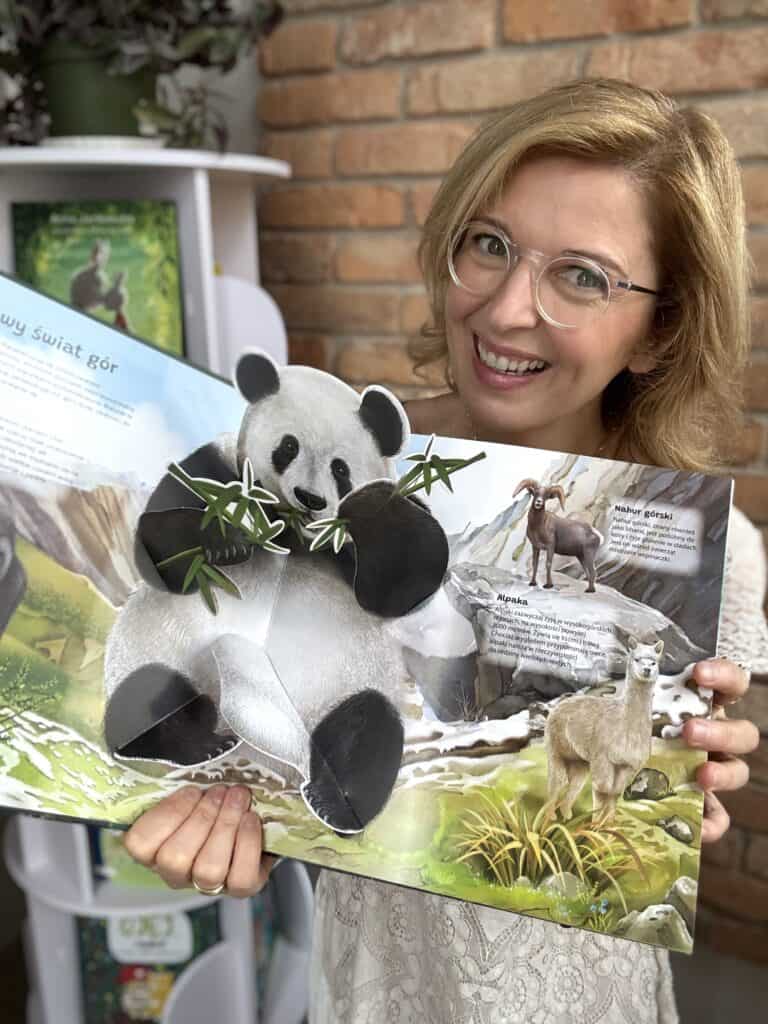 Kobieta trzyma książkę 3D o zwierzętach z ruchomymi elementami.
