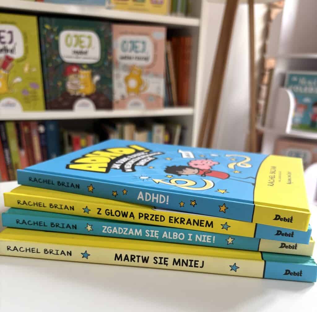 Stos czterech książek Rachel Brian w niebiesko-żółtych okładkach z logo wydawnictwa Debit, na górze tytuł „ADHD!”, a na grzbietach „Z głową przed ekranem”, „Zgadzam się albo i nie!” i „Martw się mniej