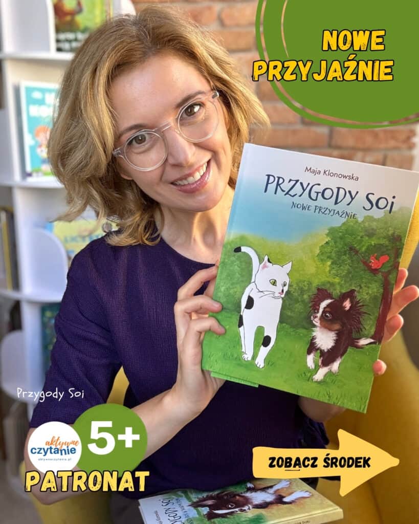 Kobieta w okularach i fioletowej bluzce trzyma okładkę książki „Przygody Soi. Nowe przyjaźnie” Mai Klonowskiej, z białym kotem i brązowym psem na zielonym tle