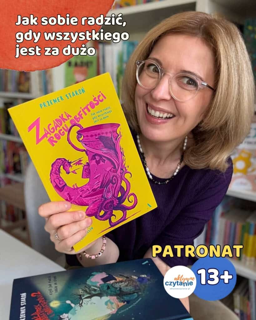 Uśmiechnięta kobieta w okularach i z naszyjnikiem z pereł trzyma żółtą książkę Przemka Staronia „Zagadka Rogu Obfitości” z różową ilustracją; na dole widać drugą książkę